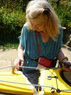 Christina Bonnett painting a kayak