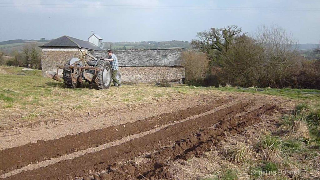 Tractor by ploughed field